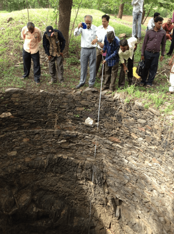 Villagers use a float and a measuring tape to monitor the water table and depth every week